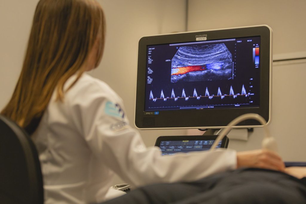 Médica acompanhando imagem de ecocardiograma no monitor